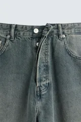 Pantalón de jean azul grisáceo con efecto lavado, corte amplio y tiro alto.