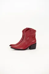 Bota texana corta de cuero color rojo, con punta fina, caña baja y taco cuadrado.