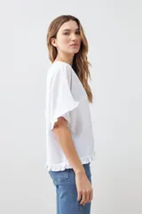 Blusa blanca con volados en mangas y ruedo.