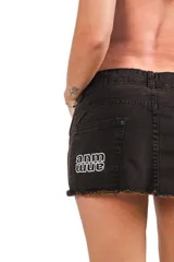 Pollera corta de denim lavado color marrón, con corte acampanado y bordado en la espalda.