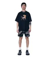 Short unisex de denim 100% algodón con acabado overo (manchado). Tiro medio, calce relajado y largo medio sobre la rodilla. Dobladillo con franja más oscura y bolsillos amplios.