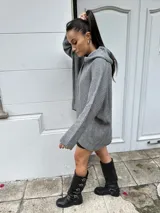 Sweater gris de tejido de punto con cuello alto y corte holgado.