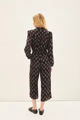 Pantalón capri negro con estampado floral, corte regular, bolsillos laterales y elástico en la parte trasera de la cintura.