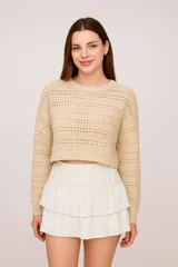 Sweater color beige de punto calado, corte crop y cuello redondo.