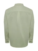 Camisa de manga larga color verde claro, confeccionada en popelina de algodón orgánico. Cuenta con cuello camisero, botones de madera, bolsillo en el pecho con logo bordado y protección UPF +20.