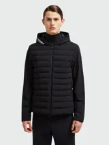 Campera acolchada negra con capucha, cierre frontal con cremallera, mangas largas y bolsillos laterales con cremallera. Detalle de logo en la capucha. Marca Moncler Grenoble.