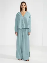 Pantalón celeste de lino italiano, de pierna ancha, con cintura elástica ajustable con cordón y bolsillos laterales.