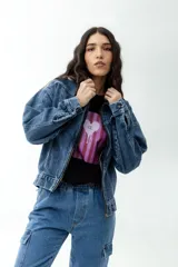 Campera de jean azul con lavado ácido, corte bomber oversize y cierre frontal con cremallera.