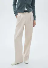 Pantalón de vestir color beige, de corte recto y tiro medio, con pinzas delanteras, bolsillos laterales y traseros.