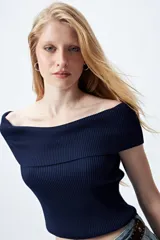 Top tejido color blanco con escote bardot que deja los hombros al descubierto y punto acanalado.