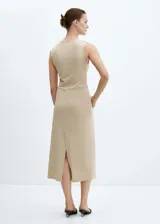 Vestido midi color beige, sin mangas y con detalle de nudo en la cintura.
