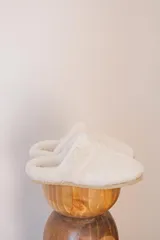 Pantuflas marrones con interior de corderito color crema.