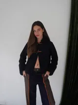 Pantalón de paño combinado con tira de cuero color naranja en los laterales.