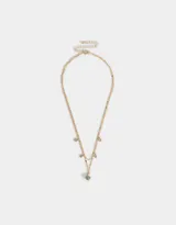 Collar corto dorado multicadena con dije de moño y mini dijes con strass.