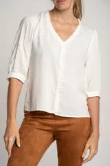 Blusa blanca de viscosa con escote en V, mangas 3/4 abullonadas y detalle de plumeti.