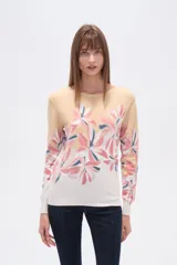 Sweater de tejido de punto, color crema, con estampado floral en tonos rosados y marrones. Presenta cuello redondo y mangas largas.