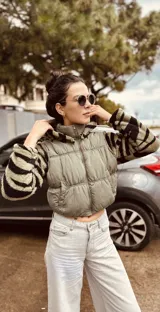 Campera puffer cropped color verde militar con mangas y capucha de polar estampado con cebra en blanco y negro.