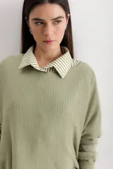 Sweater color crema de viscosa, poliéster, elastano y lurex, de corte holgado y mangas largas.