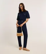 Pantalón zanahoria de cintura alta, confeccionado en tejido airflow color azul marino, con trabillas, cintura elástica y hebillas metalizadas.