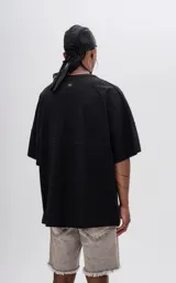 Remera negra de manga corta con calce extra oversize y recorte en delantero y espalda, confeccionada en tejido jersey 24/1 americano.