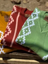 Chaleco de punto rosa con cuello en V y diseño de rombos blancos.