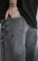 Pantalón wide leg de denim negro con lavado clásico y cinco bolsillos.