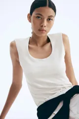 Top sin mangas en microfibra color crudo. Modelo ajustado con leve escote cuadrado y bajo recto. Parcialmente forrado.