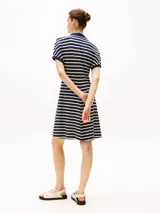 Vestido corto de corte evasé a rayas horizontales azul marino y blancas, con cuello tipo chomba azul marino y mangas cortas.