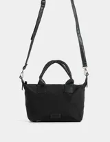 Cartera mini city color negro con doble asa corta de mano, correa regulable ajustable, cierre superior y tag de goma.