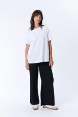 Pantalón negro de vestir, de corte palazzo y tiro alto.