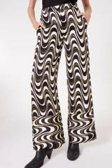 Pantalón palazzo con estampado de ondas en tonos blanco, negro y dorado.