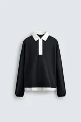 Polo negro de corte relaxed fit confeccionado en tejido con algodón. Cuello solapa con cierre frontal de botonadura. Manga larga. Bajo con aberturas laterales. Acabados en rib.