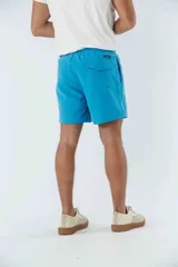 Short de baño celeste liso, con cintura elástica ajustable con cordón negro, dos bolsillos delanteros y uno trasero.