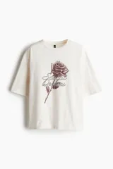 Remera oversized color crema de algodón con estampado de una rosa y la frase "Sculpt Dreams".