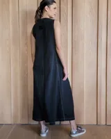 Vestido largo color crudo, sin mangas y con escote en V. Presenta aberturas laterales en el ruedo y bolsillos laterales a la altura de la cadera.