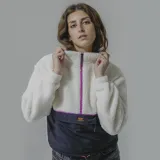 Buzo blanco de sherpa con cierre frontal de cremallera fucsia y parte inferior de nylon negro con bolsillo tipo canguro.