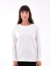 Remera beige de manga larga con cuello redondo y botones dorados en el hombro.