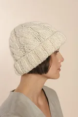 Gorro tejido a mano color crudo, con diseño de ochos, confeccionado en lana fina sin teñir.