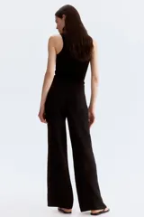 Pantalón sastrero negro de tiro alto, con pinzas adelante y atrás, confeccionado en tejido liviano de mezcla de lino y viscosa. Presenta cierre frontal con botón nacarado y piernas amplias.