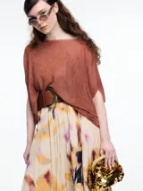 Top de punto color marrón con lurex, de silueta amplia, manga caída y escote redondo.