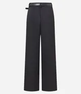 Pantalón sastrero negro de corte palazzo con pliegues delanteros, trabillas en la cintura y cinturón con hebilla metálica.