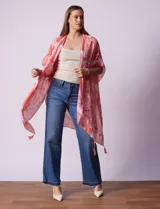 Kimono tejido con estampado abstracto en tonos grises y blancos, con mangas cortas y terminación de ruedo con borlas negras.