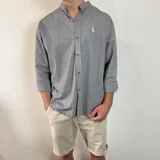 Camisa de manga larga gris con rayas verticales finas, cuello mao y bordado de un pato en el pecho.