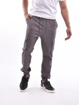 Pantalón jogger cargo color verde militar, con cintura elástica ajustable con cordón, bolsillos laterales y bolsillos cargo con solapa en los muslos.