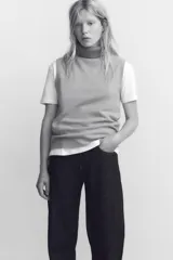 Top gris de cuello alto y sin mangas.