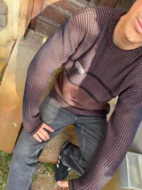 Sweater marrón con rayas horizontales azul marino, cuello redondo y parche con logo bordado en el pecho.