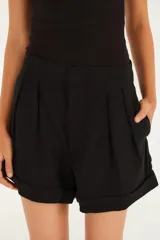 Short negro entallado con cintura alta, pliegues y bolsillos laterales.