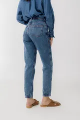 Pantalón de jean azul oscuro, corte mom, con pespuntes rojos y confeccionado en 100% algodón.