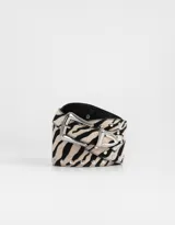 Cinturón con estampado de cebra, apliques de tachas plateadas y hebilla metálica plateada.