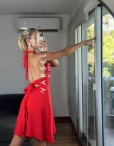 Vestido corto rojo con escote halter, espalda descubierta y falda acampanada.